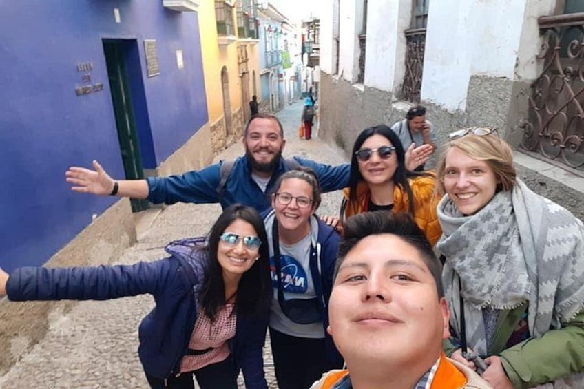 Een groep mensen maakt een selfie in een smalle straat met gebouwen aan weerszijden. 5