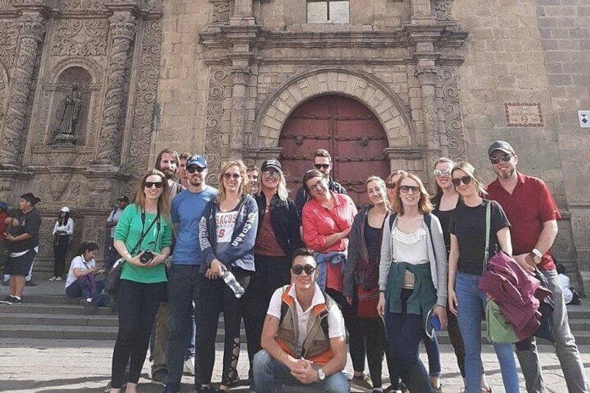 A group of people posing in front of a historic building with ornate architecture. 2