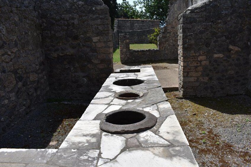 A stone pathway with circular openings leading to a gate. 2