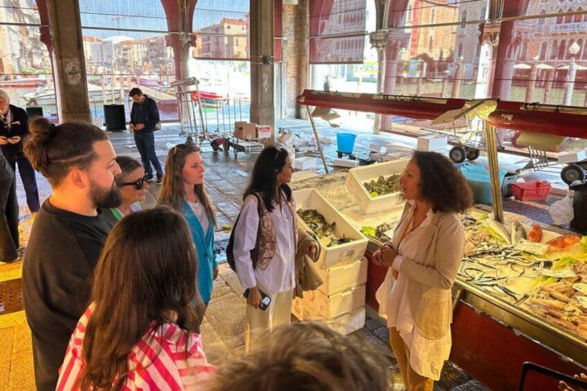 People at a market stall with seafood displays. 5