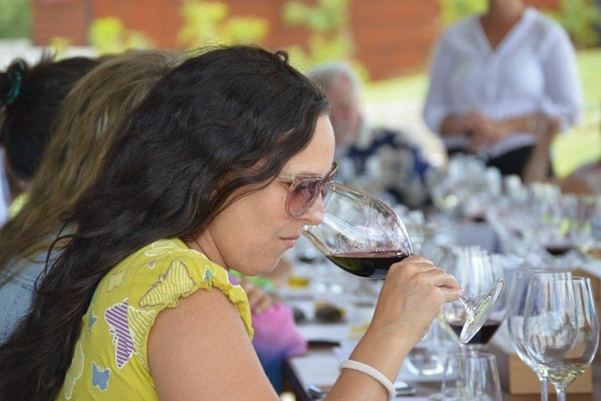 Une personne tenant un verre à vin à une table où se trouvent d’autres verres à vin vides. 1