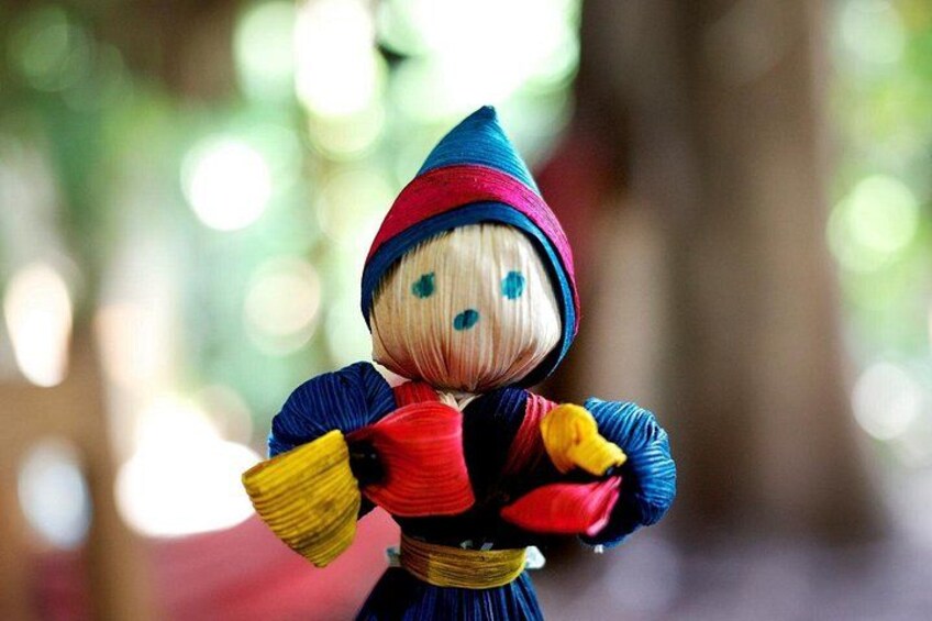 A doll with a blue and red outfit, holding a yellow object. 4