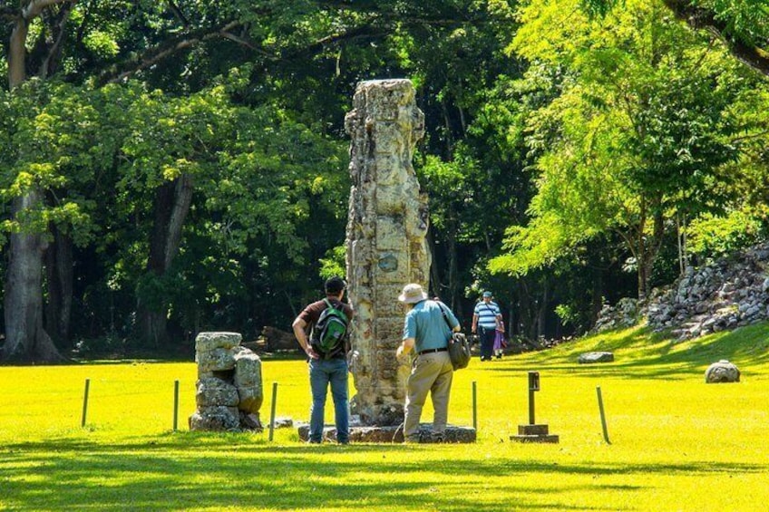 A stone monument surrounded by lush greenery and a well-maintained lawn. 1