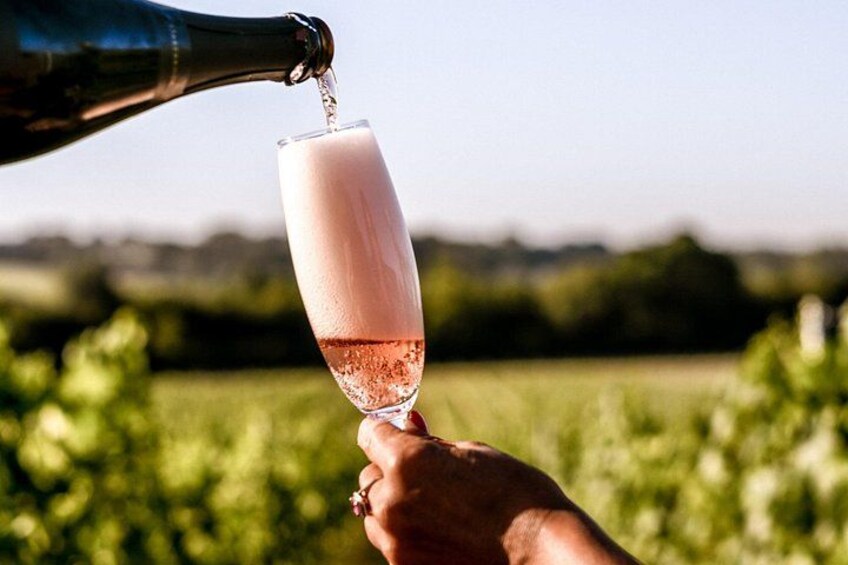 A hand holding a champagne flute being filled with champagne. 4