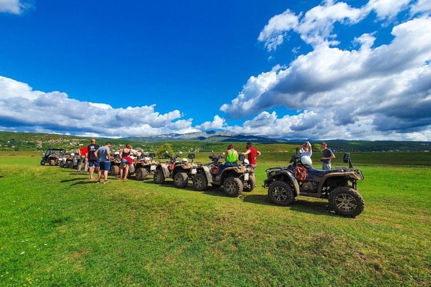 Un grupo de personas en vehículos todo terreno en un campo cubierto de hierba, con cielo despejado. 4