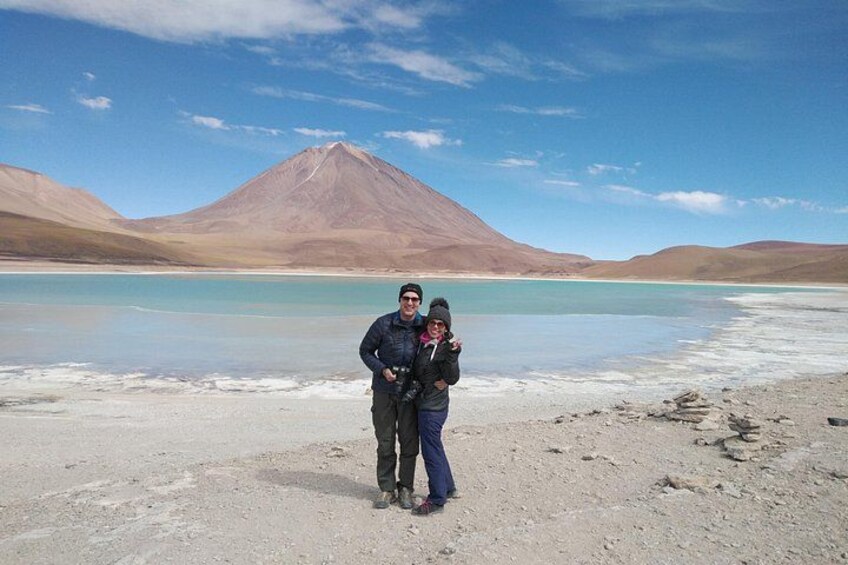 A person standing on a sandy shore with a mountain in the background. 2