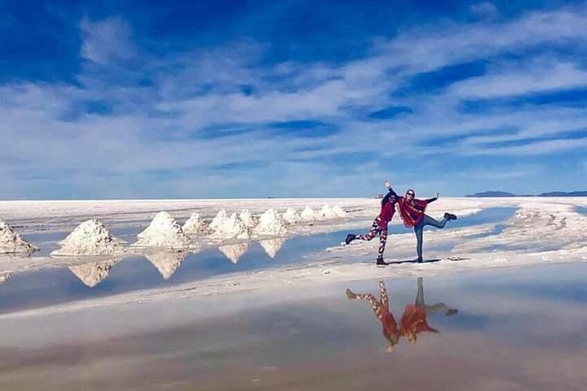 A person performing a dance in a salt flat with reflections. 5