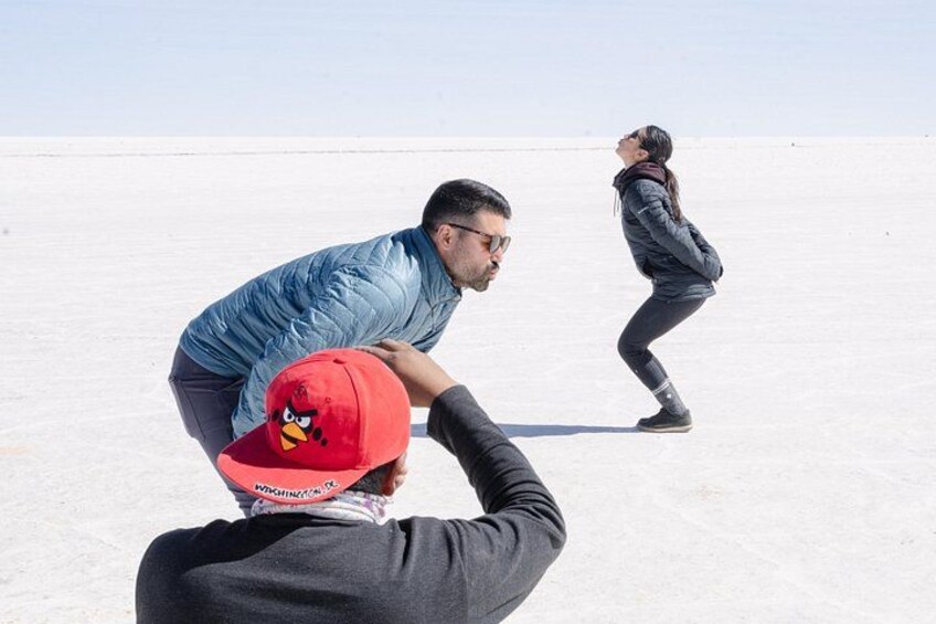 Una persona con gorra roja fotografiando a dos personas en un paisaje desértico. 2