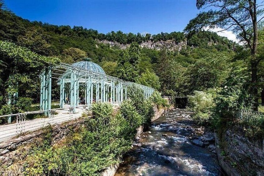 A glasshouse structure, a river, and a forested hillside. 5