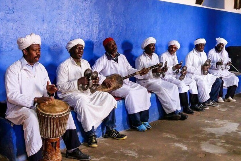 A group of musicians in traditional attire playing various instruments. 4