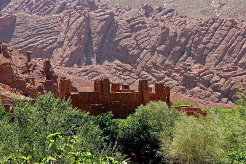 A desert landscape with a ruined structure amidst red rock formations. 3