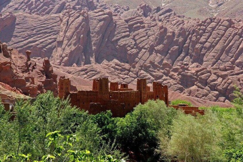 A historic stone structure with ruins in a rocky, red-hued landscape. 3