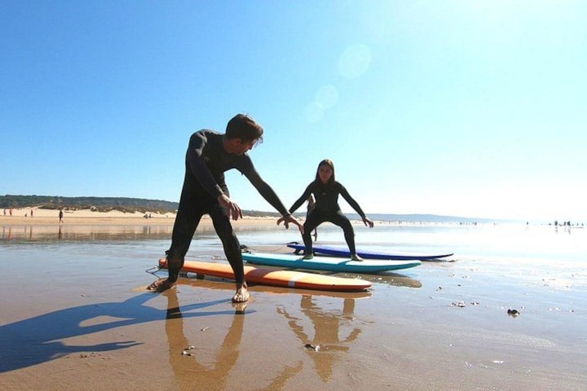 A person in a wetsuit on a beach with surfboards. 4
