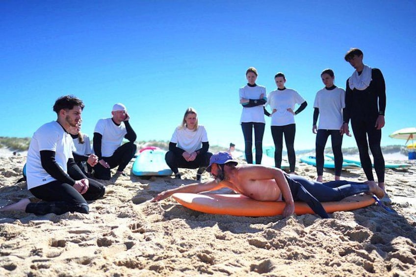 A group of people on a sandy beach with surfboards. 3