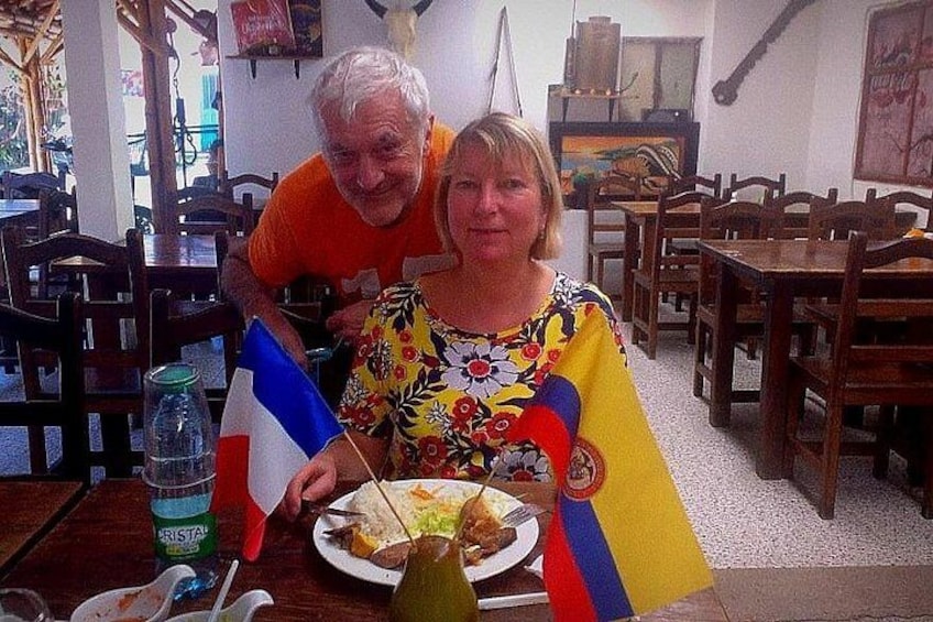 A dining table with a plate of food, a bottle, and two flags. 5