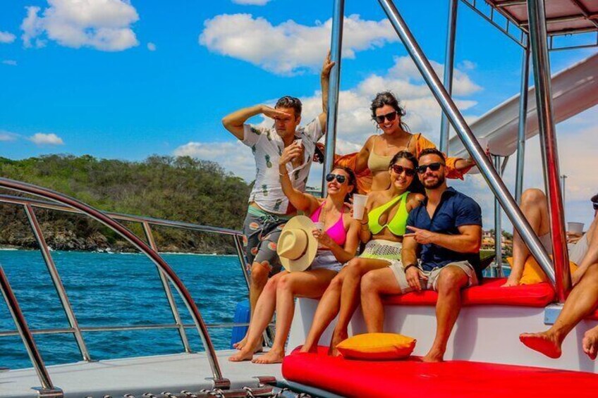 A group of people on a boat with a clear blue sky and calm sea. 1