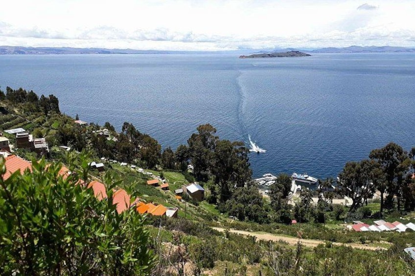 A coastal landscape with houses, a boat, and a distant island. 3