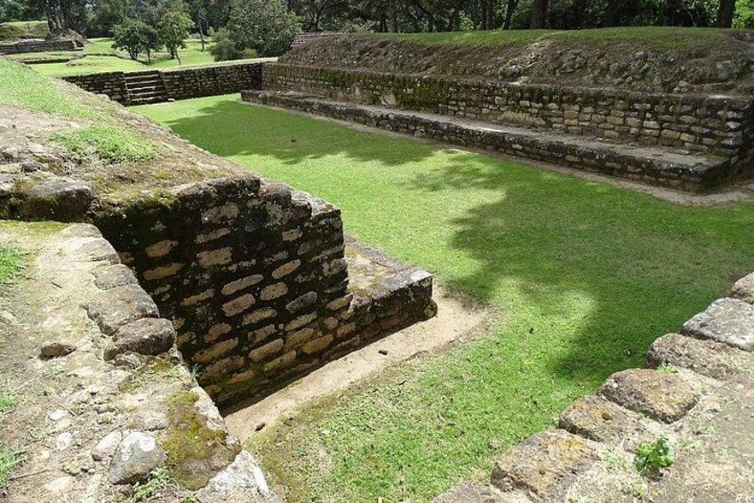 Ancient stone structures with a grassy field in the foreground. 5