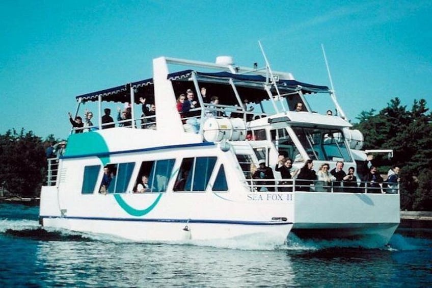 A ferry with multiple decks and passengers, sailing on water. 1