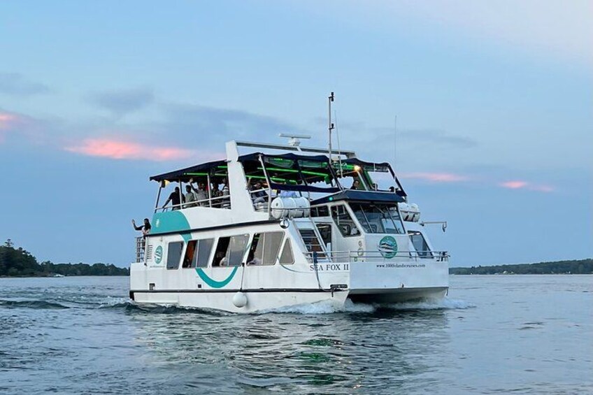 A white boat with a green logo and the name 'SEA FOX II' on the side, moving on calm water. 2