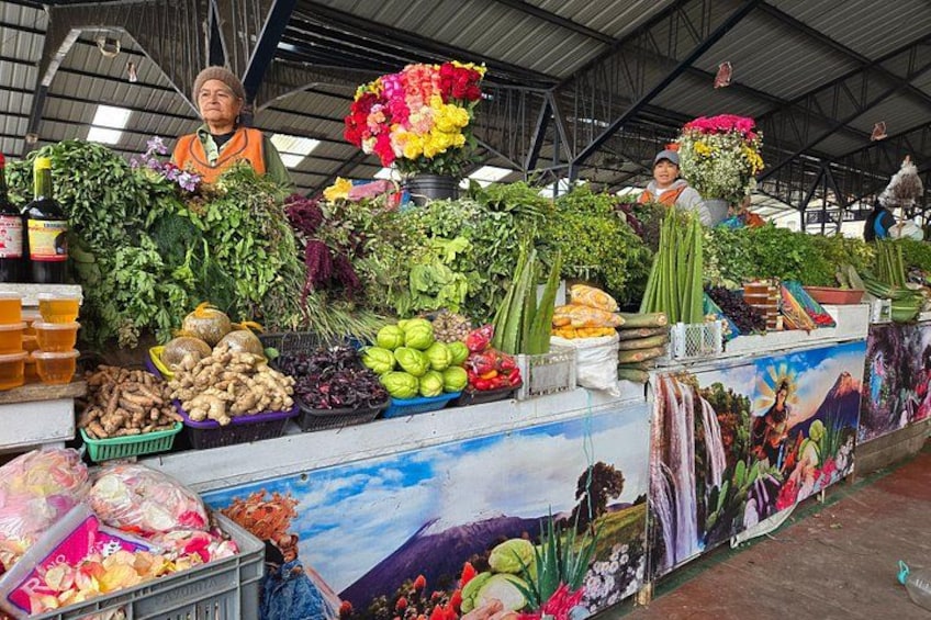 A market stall with various vegetables and flowers. 2