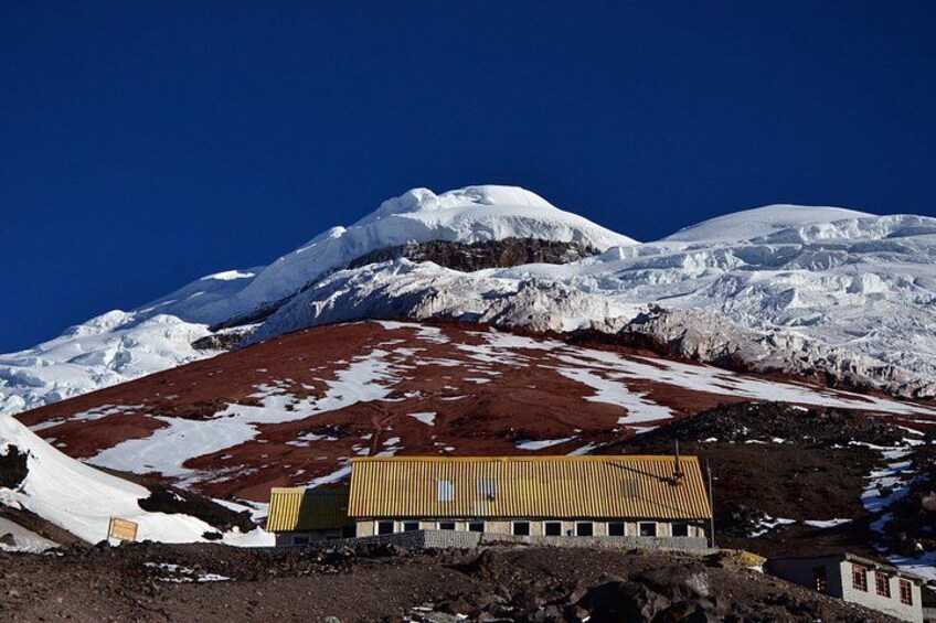 A snow-covered mountain with a building in the foreground. 5