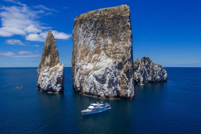 A boat near large rock formations in the sea. 2