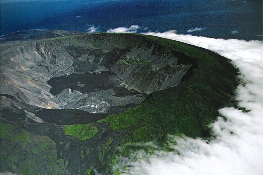 A large crater surrounded by lush green vegetation and a coastline. 5