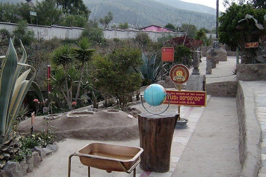 A garden with a globe, a wooden wheelbarrow, and a sign with a date. 3