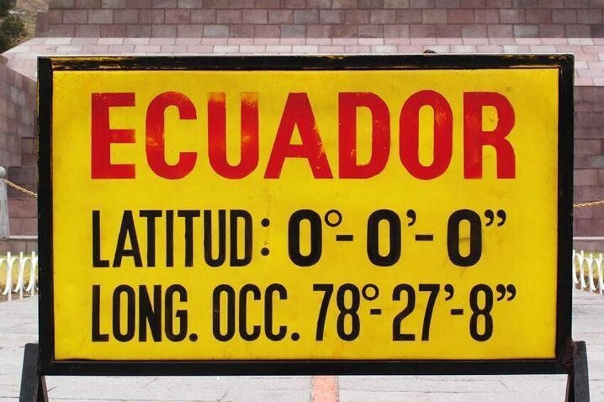 A sign with the word 'ECUADOR' and coordinates. 5