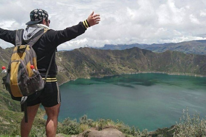 Una persona parada en la cima de una montaña, con vistas a un lago. 2