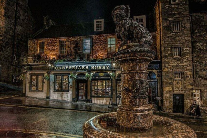 En historisk bygning kaldet 'Greyfriars Bobby' med en løvestatue af sten foran. 2