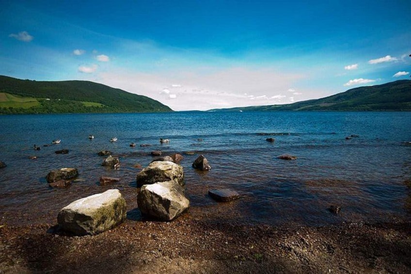 A lake with clear water, surrounded by hills and rocks. 3