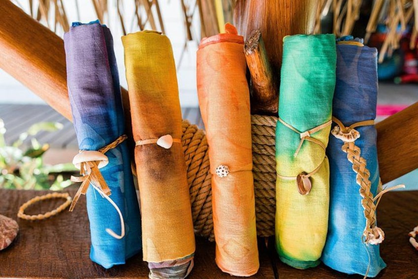 A collection of colorful, rolled-up items tied with twine, displayed on a wooden surface. 5