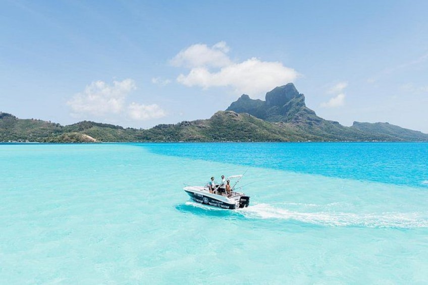 Un bateau sur une eau turquoise, avec un paysage montagneux en arrière-plan. 1