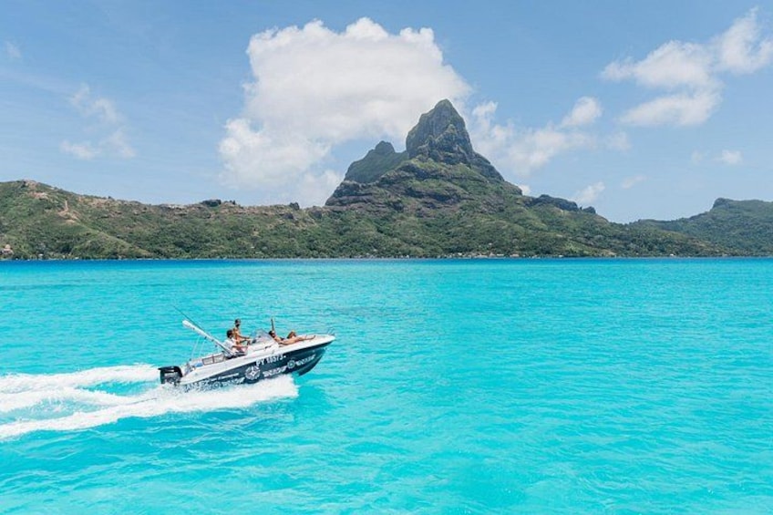 Un bateau sur une eau turquoise, avec une île montagneuse en arrière-plan. 4