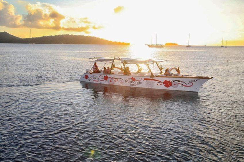 Un bateau sur lequel on peut lire les mots « Excursion romantique », naviguant sur une eau calme, avec un coucher de soleil en arrière-plan. 2