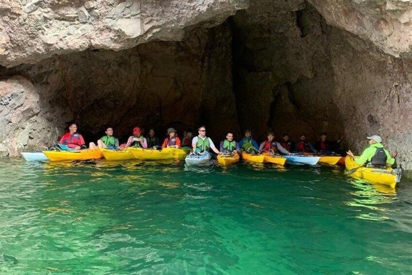 A group of people in yellow kayaks inside a cave. 3