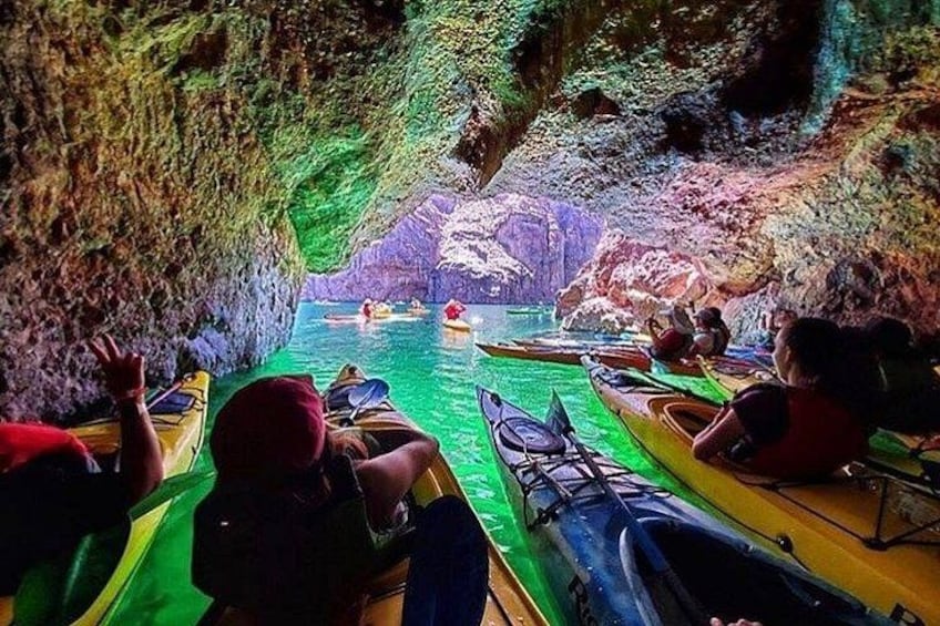 People kayaking in a cave with water. 1