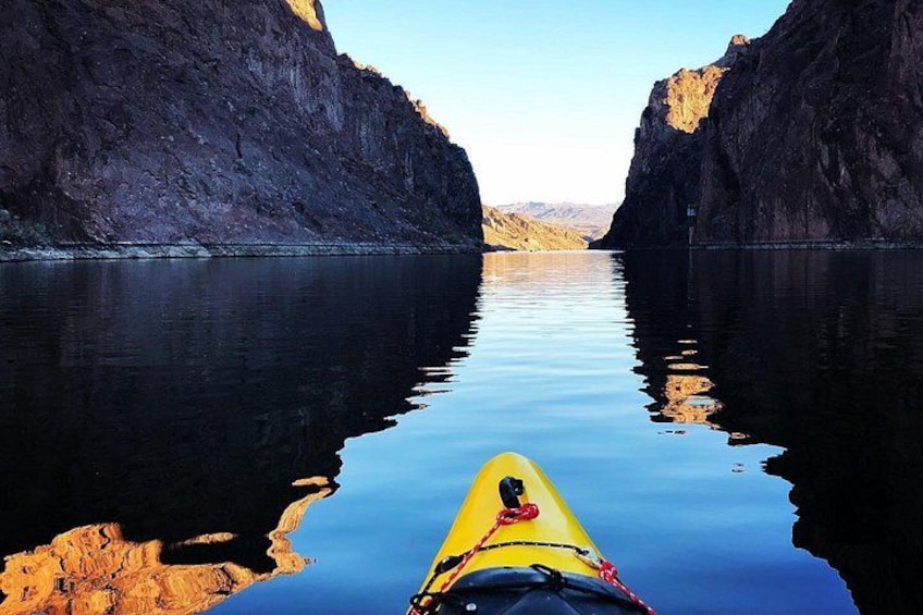 A kayak on calm water between steep rock cliffs. 2