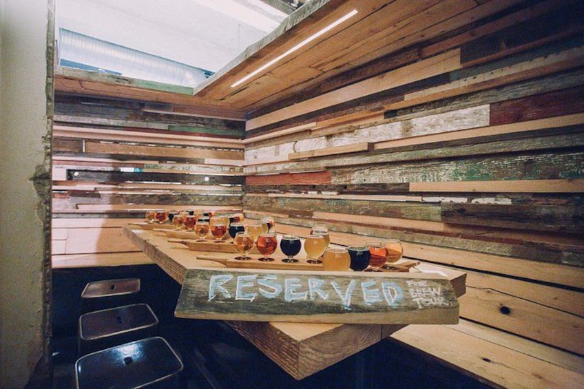 Un interno in legno con un lungo tavolo che espone diverse bevande e un cartello con la scritta 'RESERVED'. 5