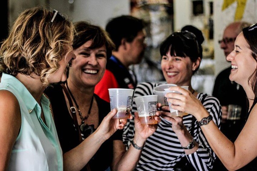 Un grupo de personas brindando con vasos de plástico. 1