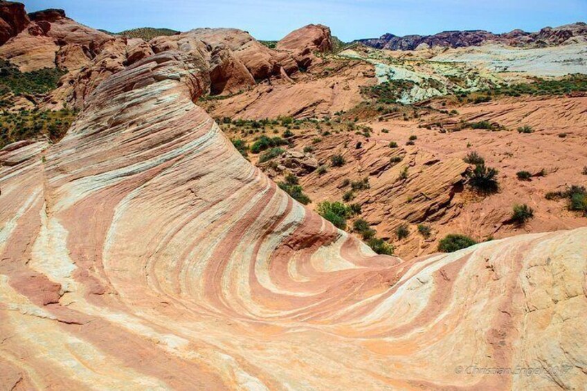 A large rock formation with layered colors and a desert landscape. 2