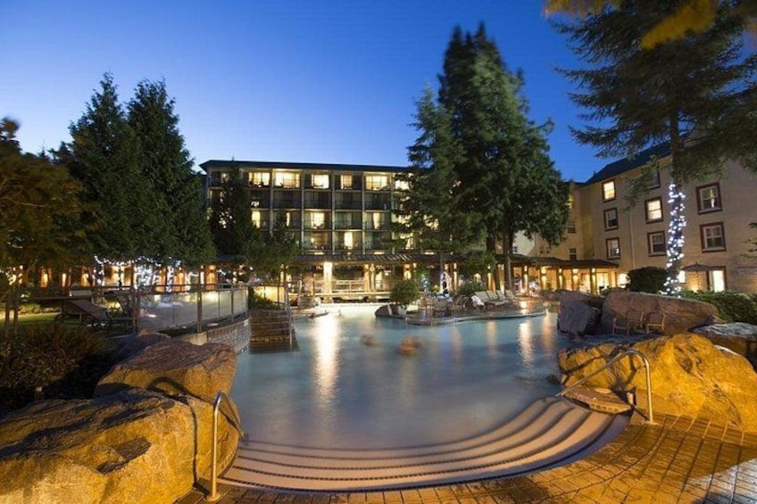 Une piscine dotée d’une terrasse circulaire, entourée de gros rochers et d’arbres. 5