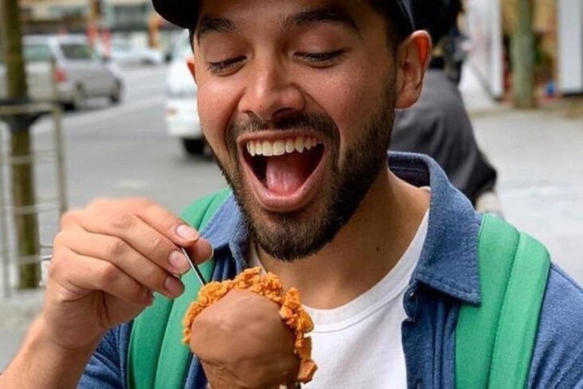 A person eating a food item outdoors. 1