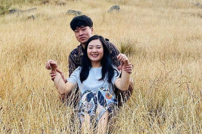 Two people sitting in a field of tall grass. 2