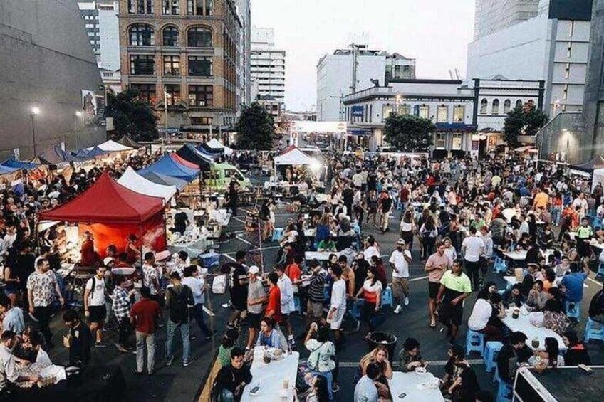 Un mercado al aire libre concurrido, con numerosos puestos y gente. 3