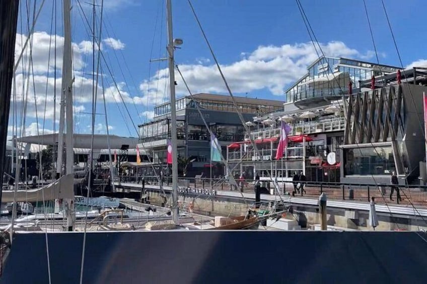 Een jachthaven met boten, een modern gebouw en een heldere lucht. 2