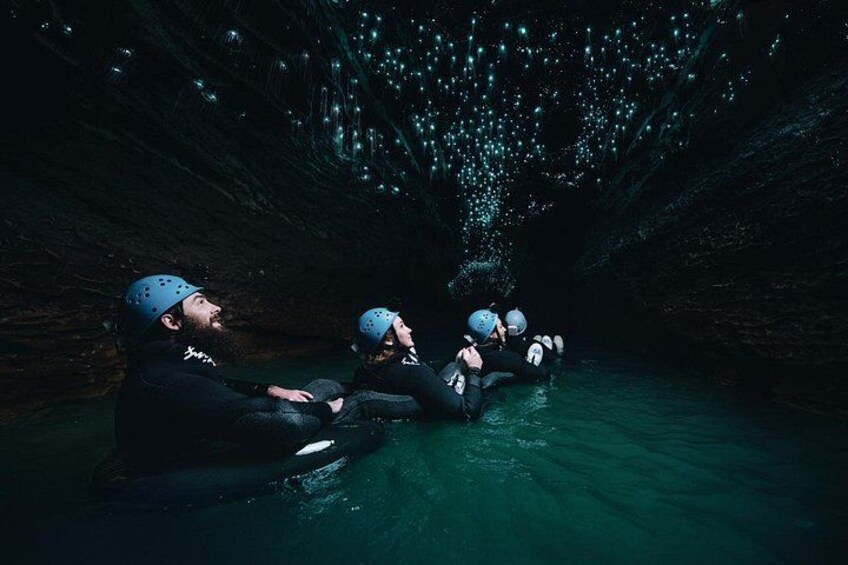 Människor i en grotta med lysande lampor ovanför. 2