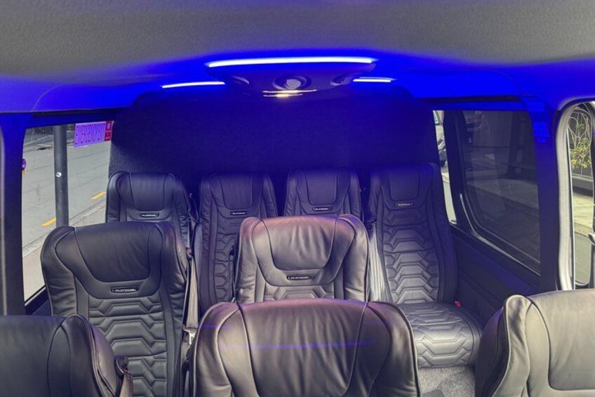 A vehicle interior with leather seats and blue ambient lighting. 4